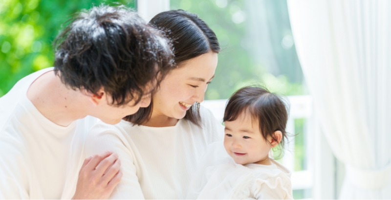 子どもを見つめる両親
