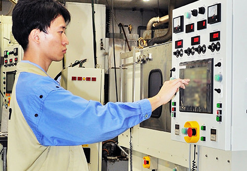 研削盤を操作しているところ